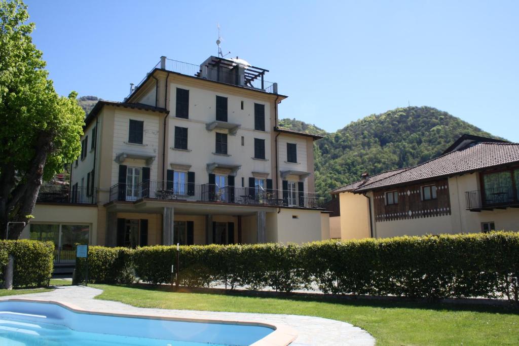 a house with a swimming pool in front of it at Hotel La Torre in Castiglione dʼIntelvi