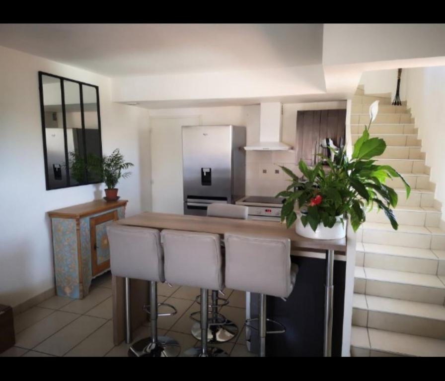 une cuisine avec un bar avec des tabourets et un comptoir dans l'établissement T3 duplex malibu village pass piscine en supplément 2 a 8 personnes, à Canet