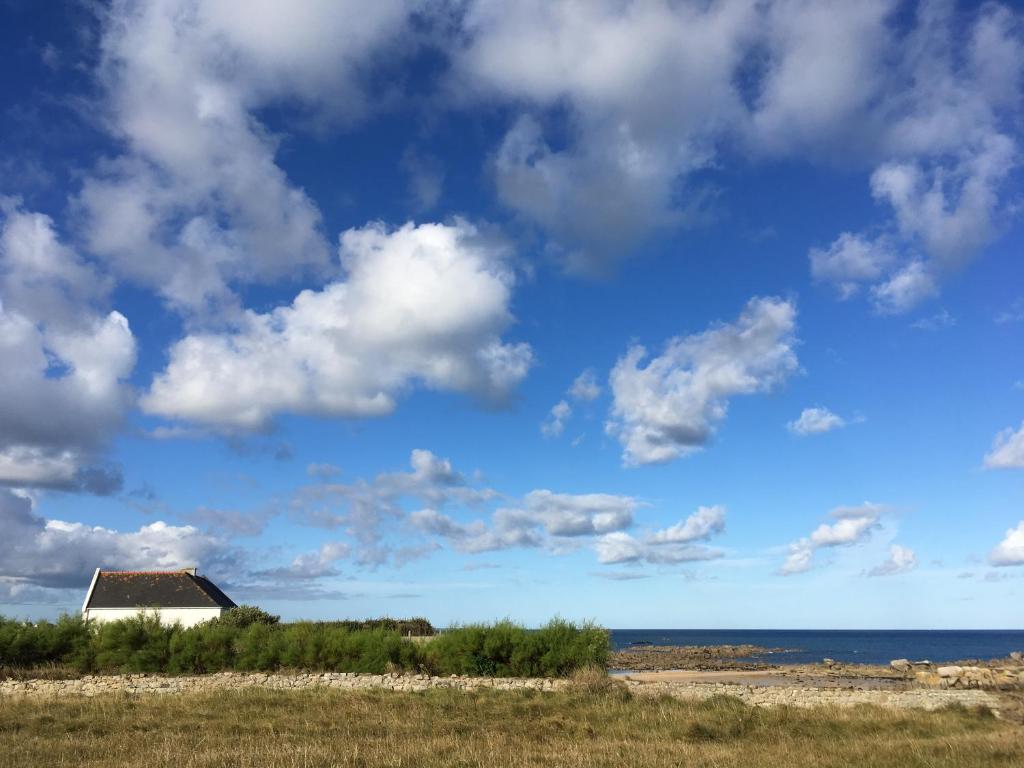 普盧埃斯卡的住宿－Das Haus auf der Düne，海滩上多云的天空下的房子