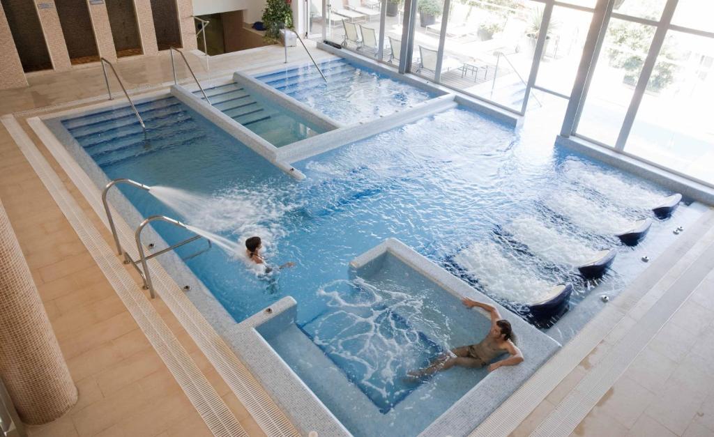 two people swimming in a swimming pool at ARTIEM Audax - Adults Only in Cala Galdana