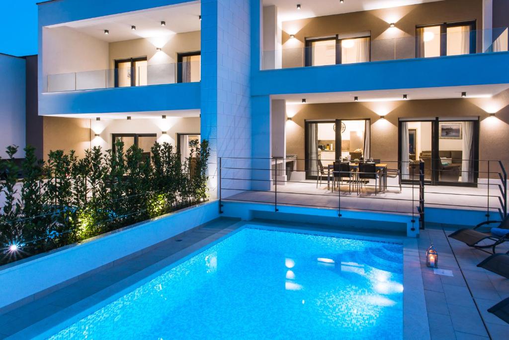a villa with a swimming pool in front of a building at View Villas Collection in Vinišće
