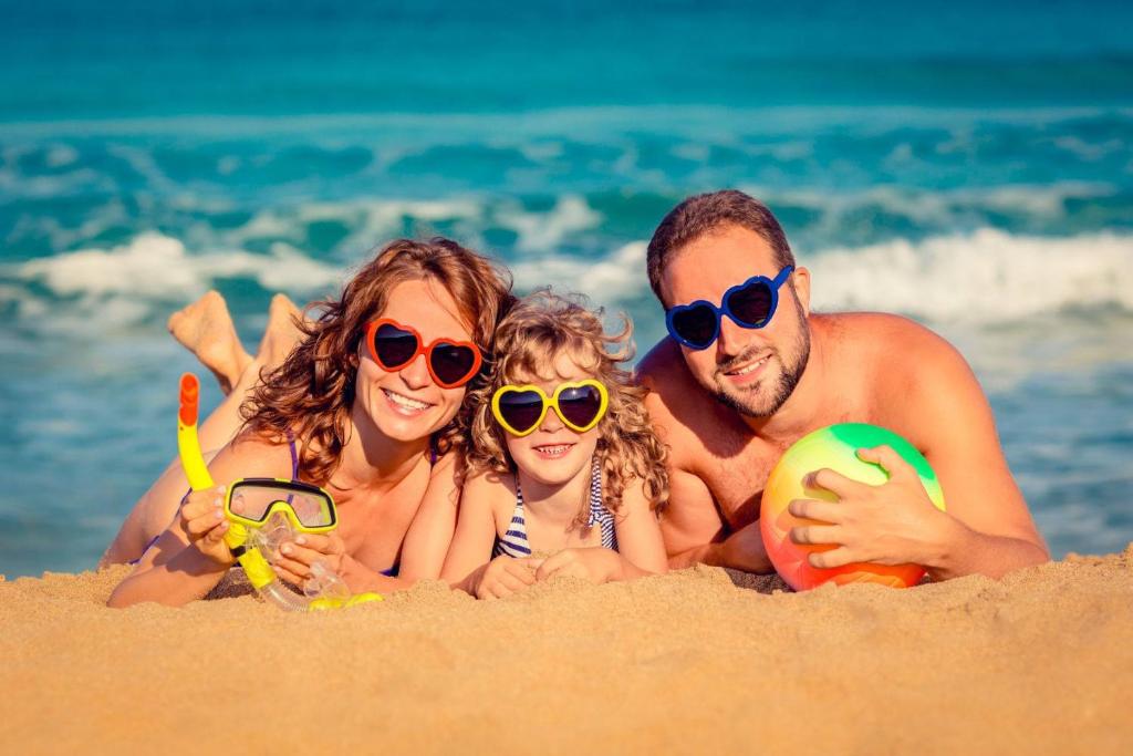 una familia yaciendo en la arena en la playa en Residence Solar - Family Friendly, en Torre Ovo