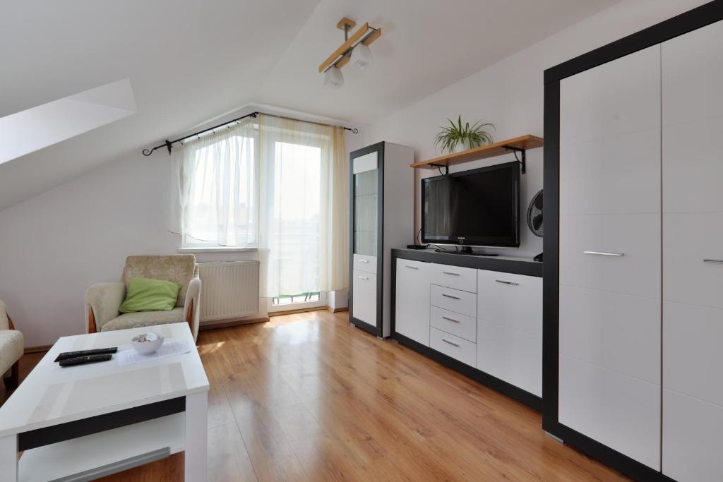 ein Wohnzimmer mit einem TV und einem Sofa in der Unterkunft Apartament Słoneczny 1 in Oppeln