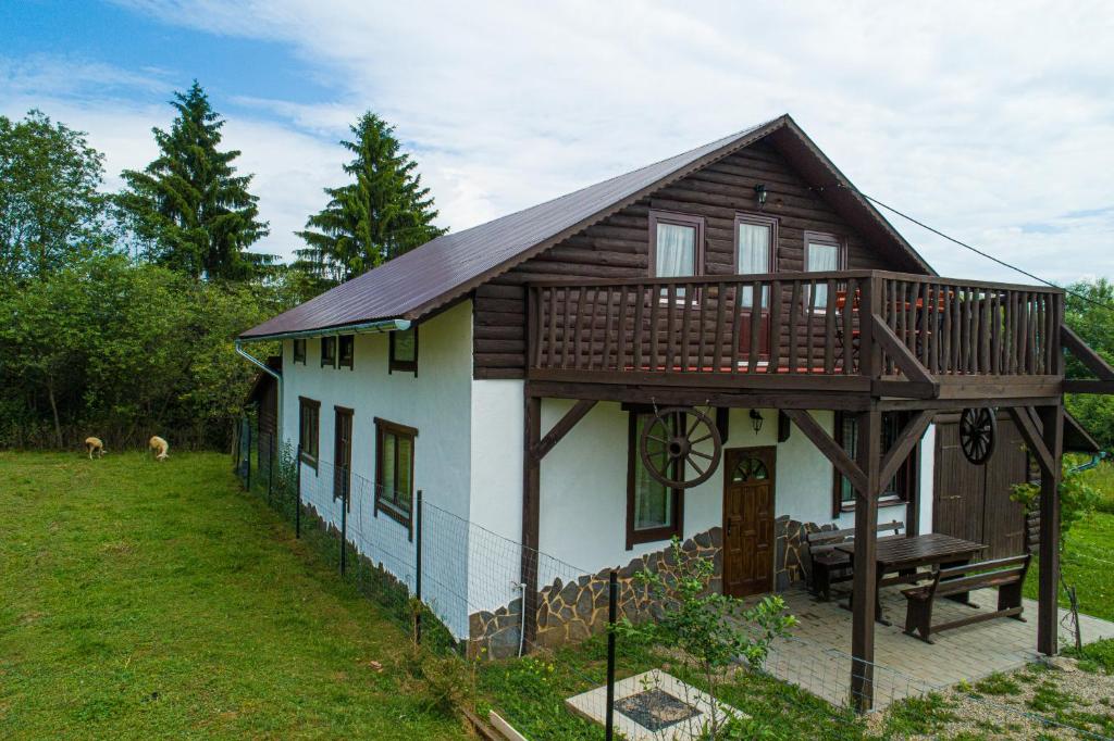 uma pequena casa com um alpendre e um deque em Kristóf vendégház em Ciumani