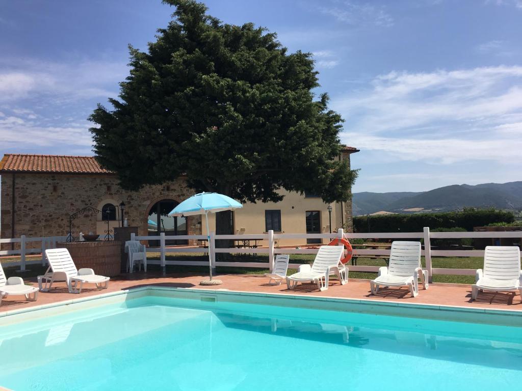 a swimming pool with lounge chairs and an umbrella at Casale Poggio Meone in Santa Luce