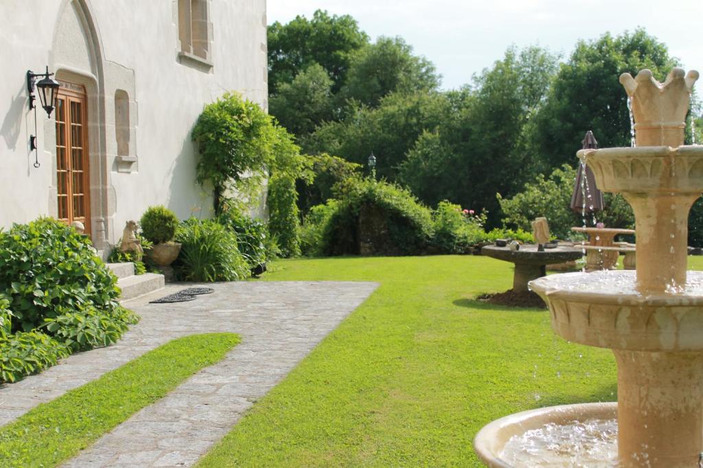 einen Garten mit einem Brunnen inmitten eines Gartens in der Unterkunft Manoir XV Domaine de Peyrafort in Tulle