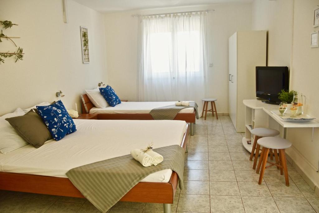 Habitación de hotel con 2 camas y TV en Apartments Off, en Supetar
