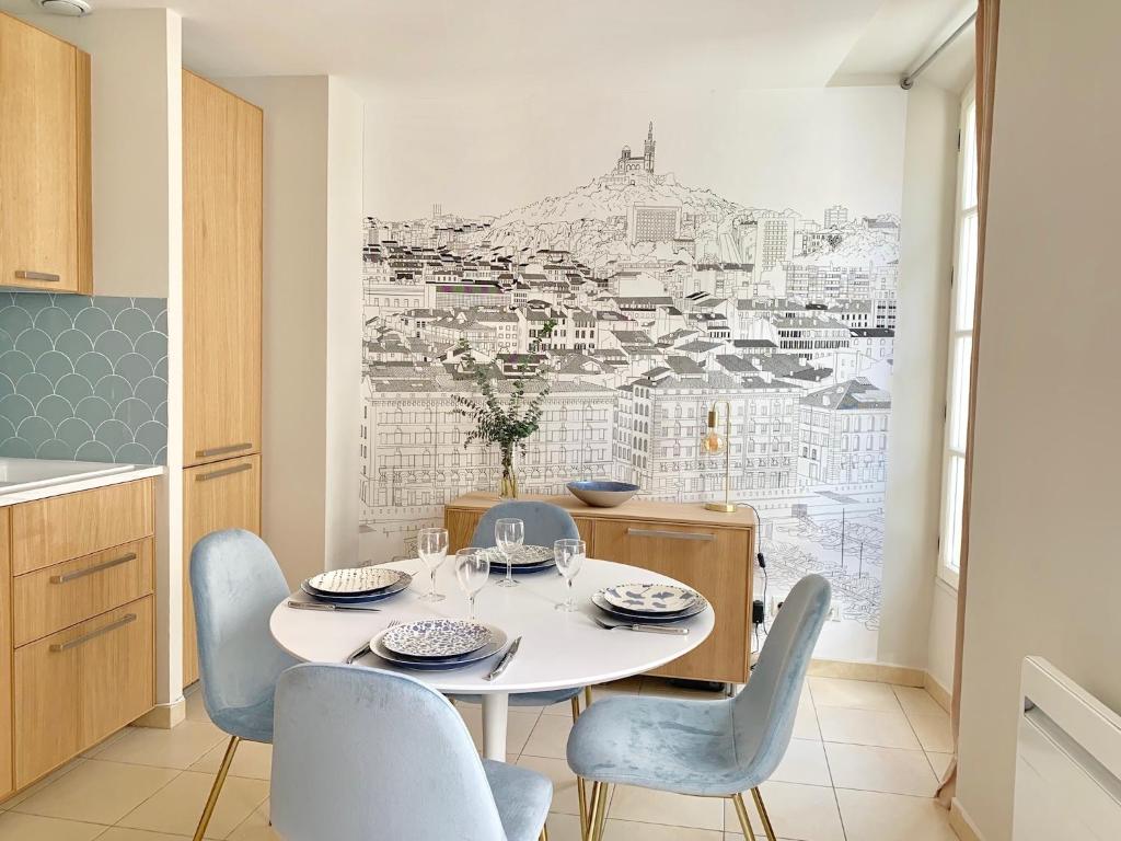 a dining room with a white table and chairs at L'Escale au Coeur du Vieux Port de Marseille in Marseille