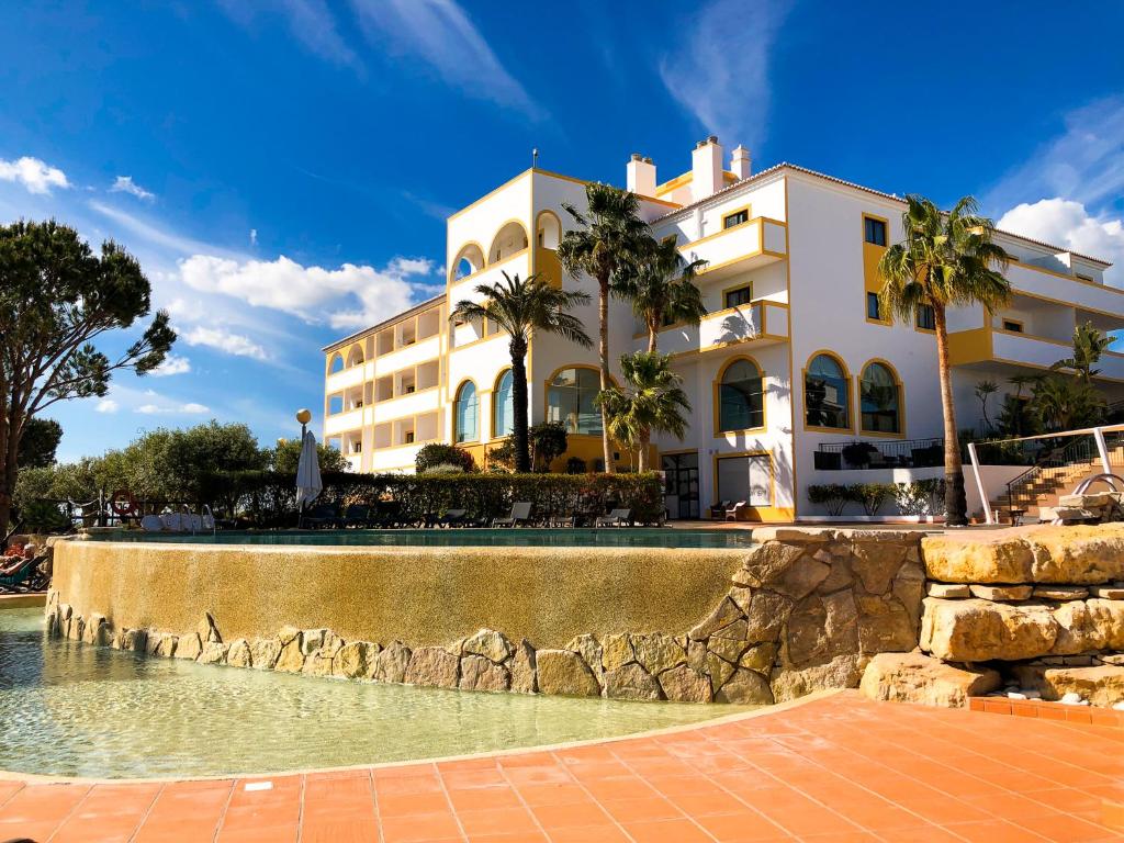 a building with a swimming pool in front of a building at Vale d'El Rei Hotel & Villas in Carvoeiro