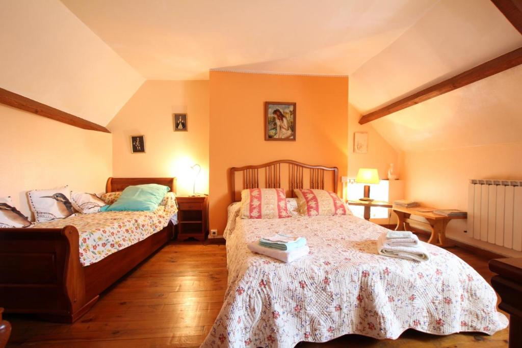 two beds in a bedroom with orange walls at Chambre d'hôtes in Pontacq