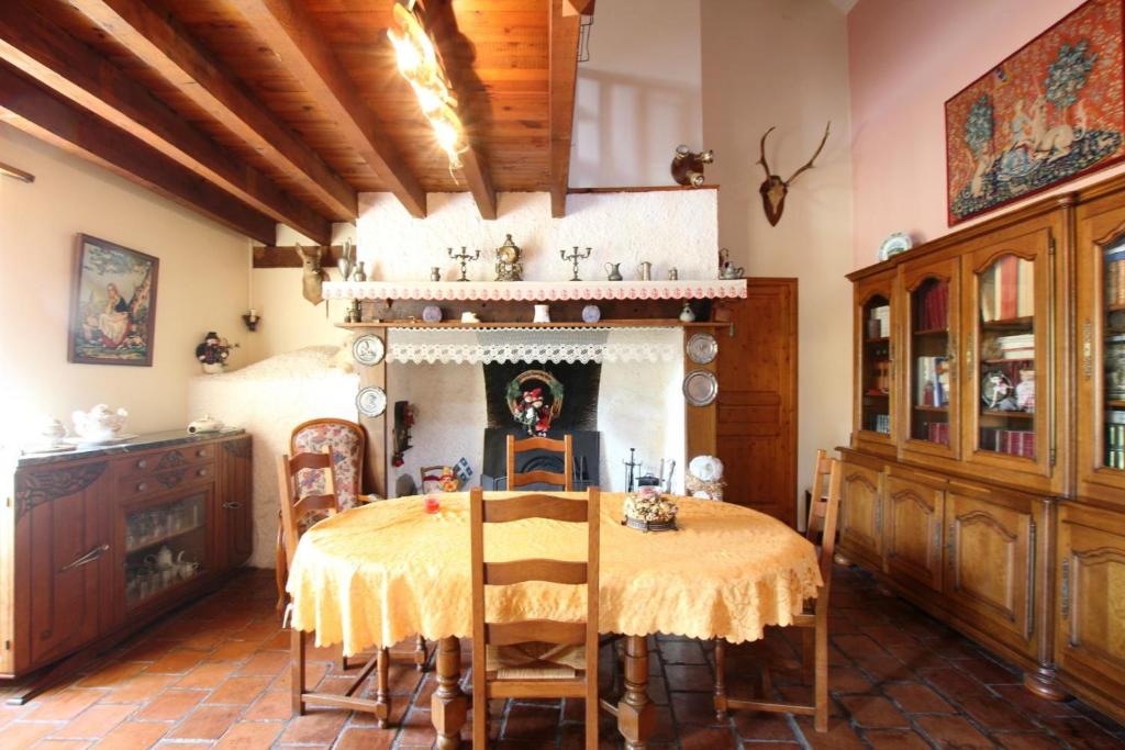 a dining room with a table and a fireplace at Chambre d'hôtes in Pontacq