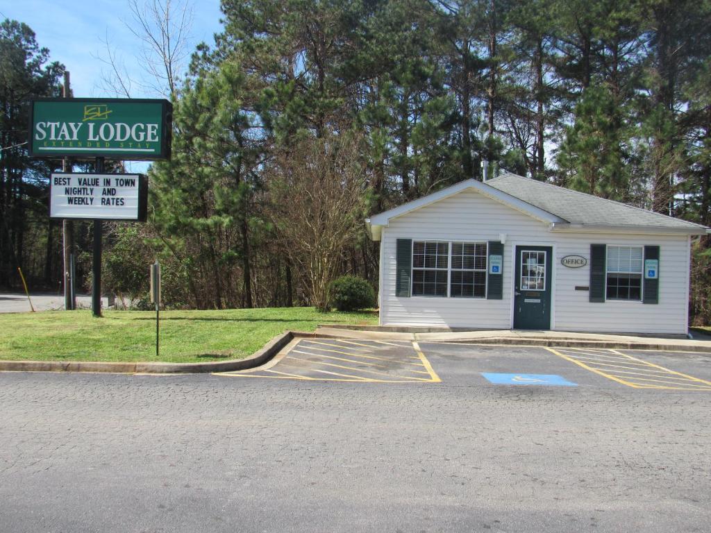 un pequeño edificio blanco con un cartel delante en Stay Lodge Anderson en Anderson