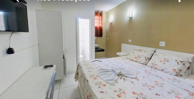 ein Schlafzimmer mit einem Bett mit einer Schleife darauf in der Unterkunft Capivari Centro Hotel in Capivari