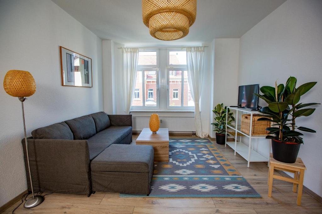 ein Wohnzimmer mit einem Sofa und einem TV in der Unterkunft Stadtperle am plätschernden Wasser - 50m2 Zweiraumwohnung in zentraler Lage in Erfurt
