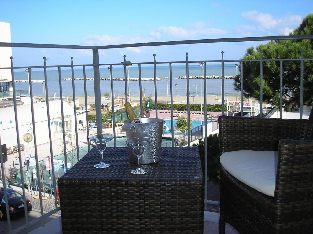 einen Tisch mit zwei Weingläsern auf dem Balkon in der Unterkunft Hotel Playa in Rimini