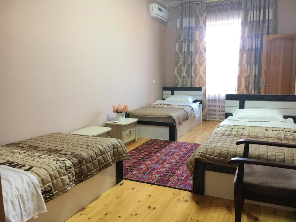 um quarto com 2 camas, uma janela e um tapete em Brown Hill em Samarkand