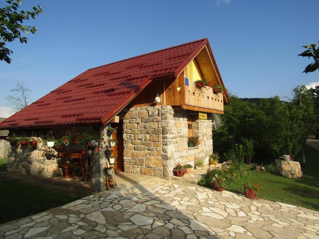 un piccolo edificio in pietra con tetto rosso di Guest house Emanuela a Slunj