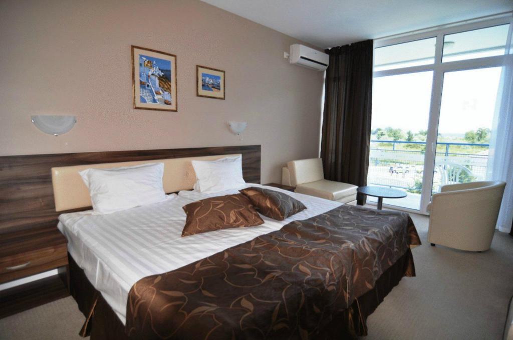 Un dormitorio con una cama grande y una ventana grande. en Regata Palace Hotel, en Sunny Beach
