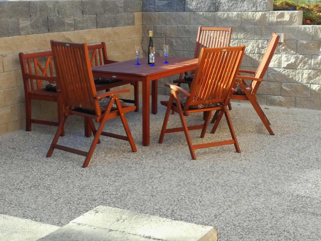 uma mesa de madeira e quatro cadeiras com copos de vinho em Apartma Marjetica II. em Blejska Dobrava
