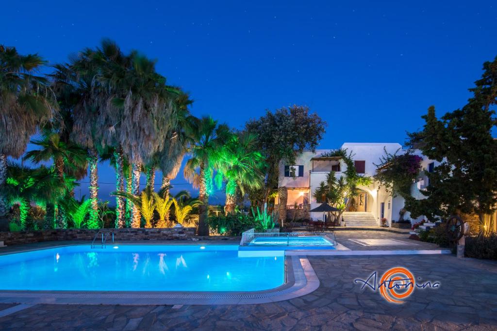 una piscina en un patio con palmeras en Antonina Hotel, en Agia Anna de Naxos