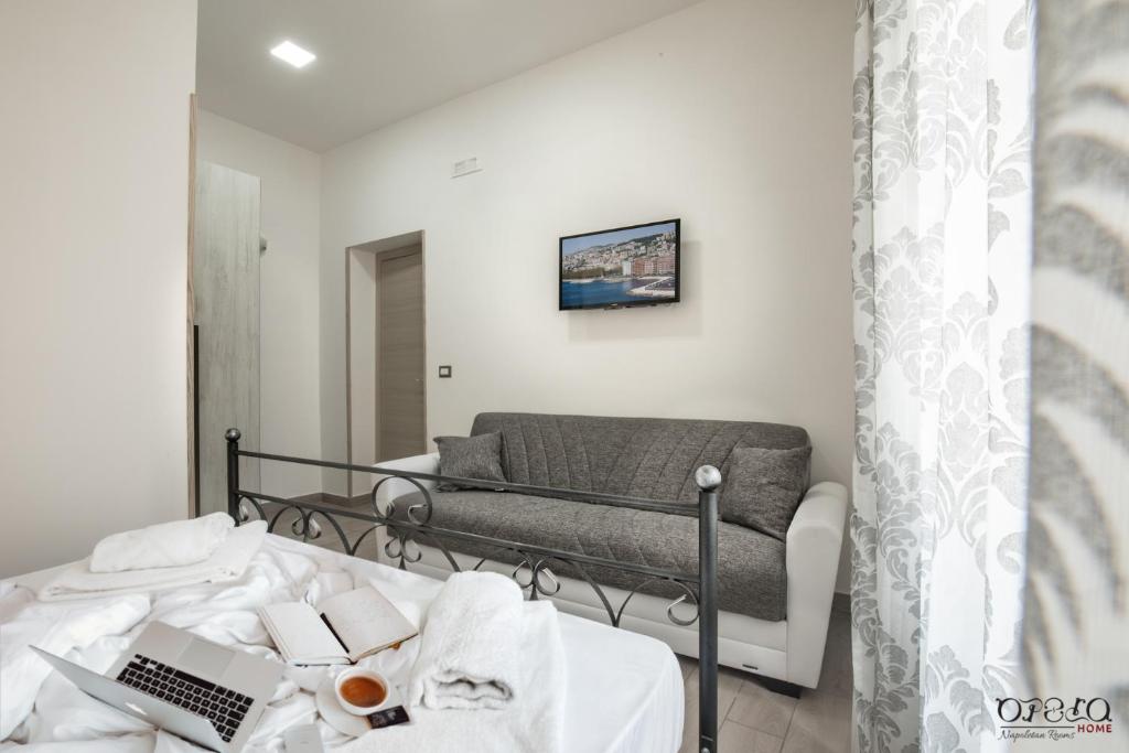 1 dormitorio con 1 cama con ordenador portátil en Opera Home Principe Umberto, en Nápoles