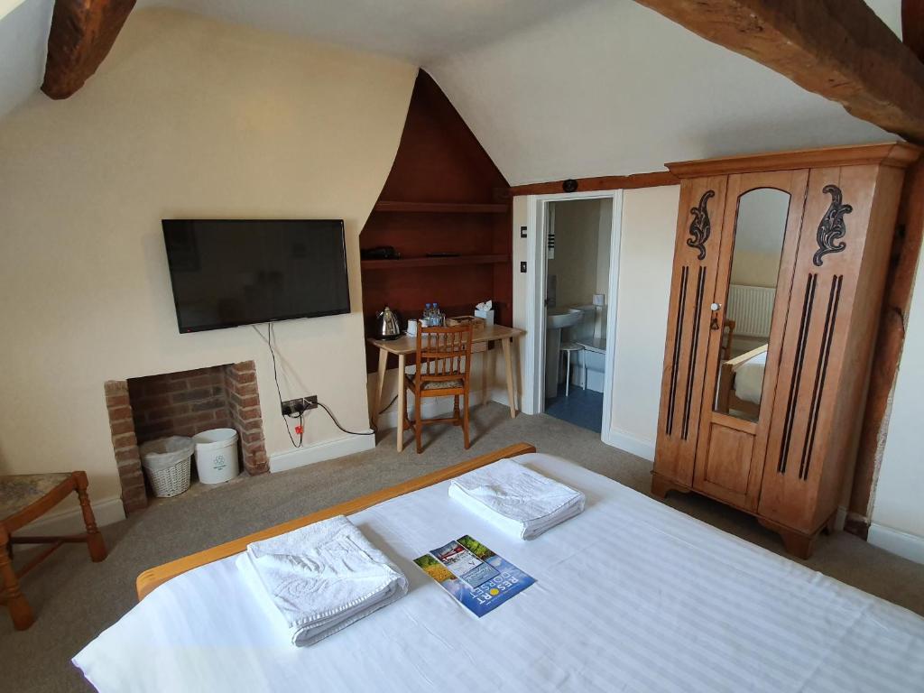 Un dormitorio con una cama y un televisor de pantalla plana. en Alexandra Hotel, en Weymouth