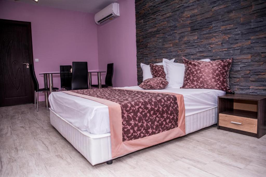 a bedroom with a large bed and a brick wall at Апартамент България със свободна зона за паркиране in Veliko Tŭrnovo
