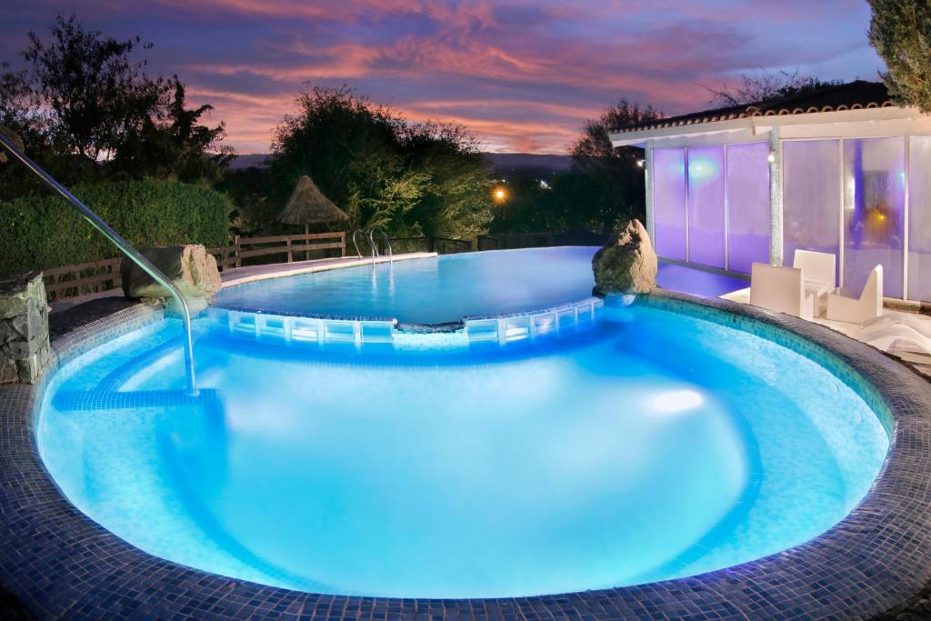 a large swimming pool with blue water at night at Terrazas de Belgrano - Club de Montaña in Villa General Belgrano