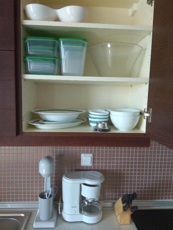szafka z talerzami i miskami na blacie kuchennym w obiekcie Fotini's Apartment w mieście Néa Péramos