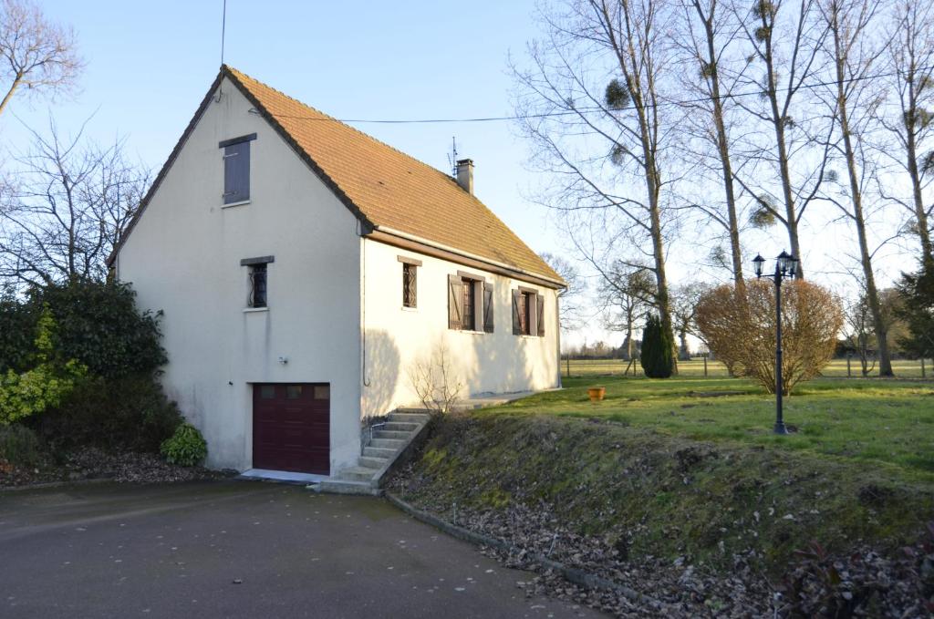 a small white house with a red door at CHAMBRES chez L'HABITANT in Saint-Paul-du-Vernay