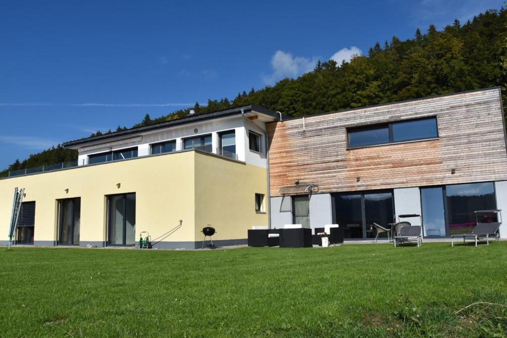 a building with a grass field in front of it at Chez Julia in Tramelan