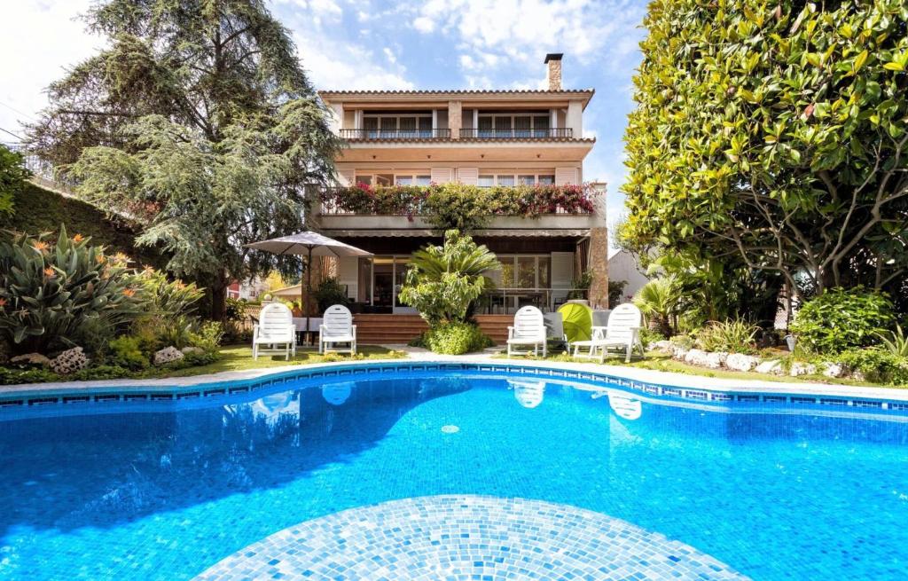 a house with a swimming pool in front of a house at Villa Paquita in Calella