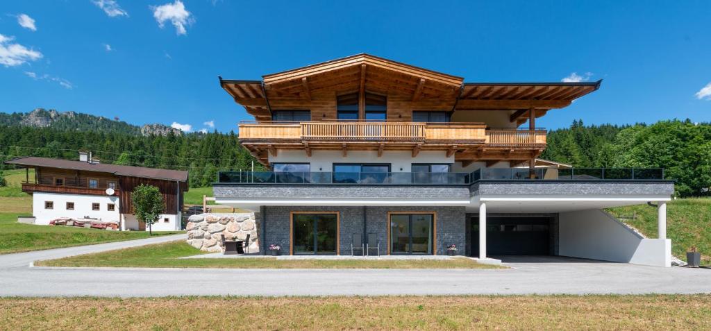 uma casa grande com telhado de madeira em Ferienwohnung App. MOUNTAIN VIEW em Fieberbrunn