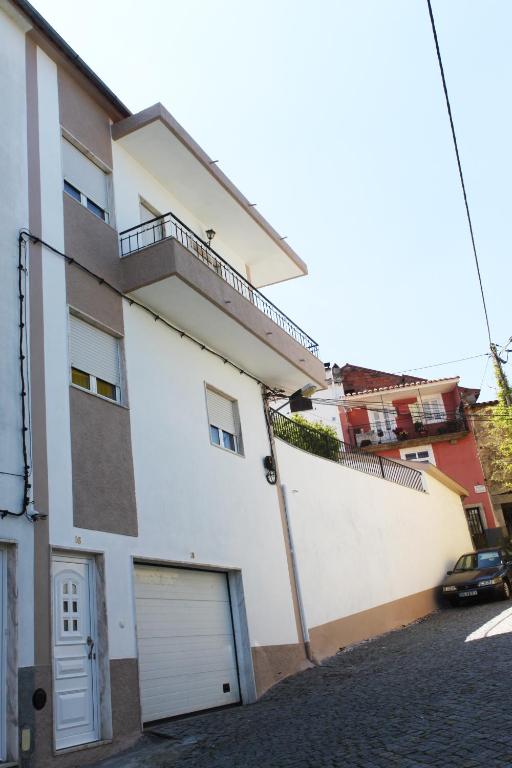 a white apartment building with a garage at Casa do Neto Tiago in Fundão