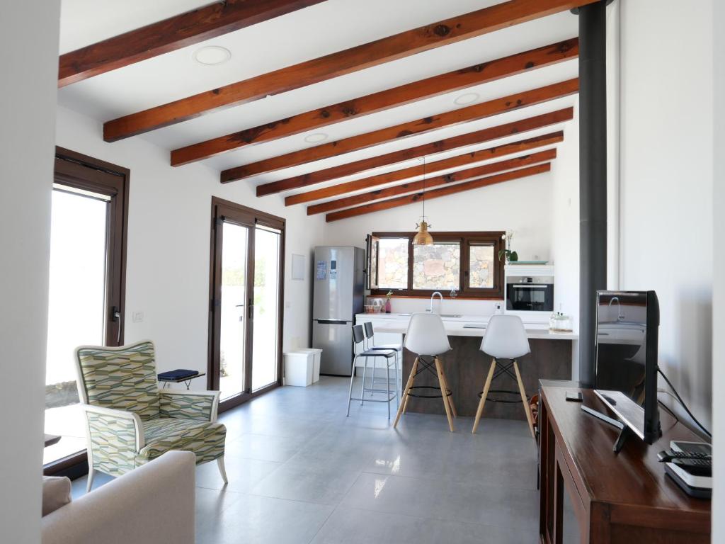 cocina y sala de estar con paredes blancas y techos de madera. en Casa Viges, en El Pinar de El Hierro