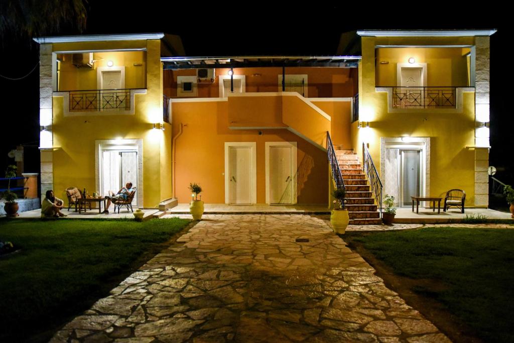 a house at night with people sitting in the yard at Casa del mar in Kavos