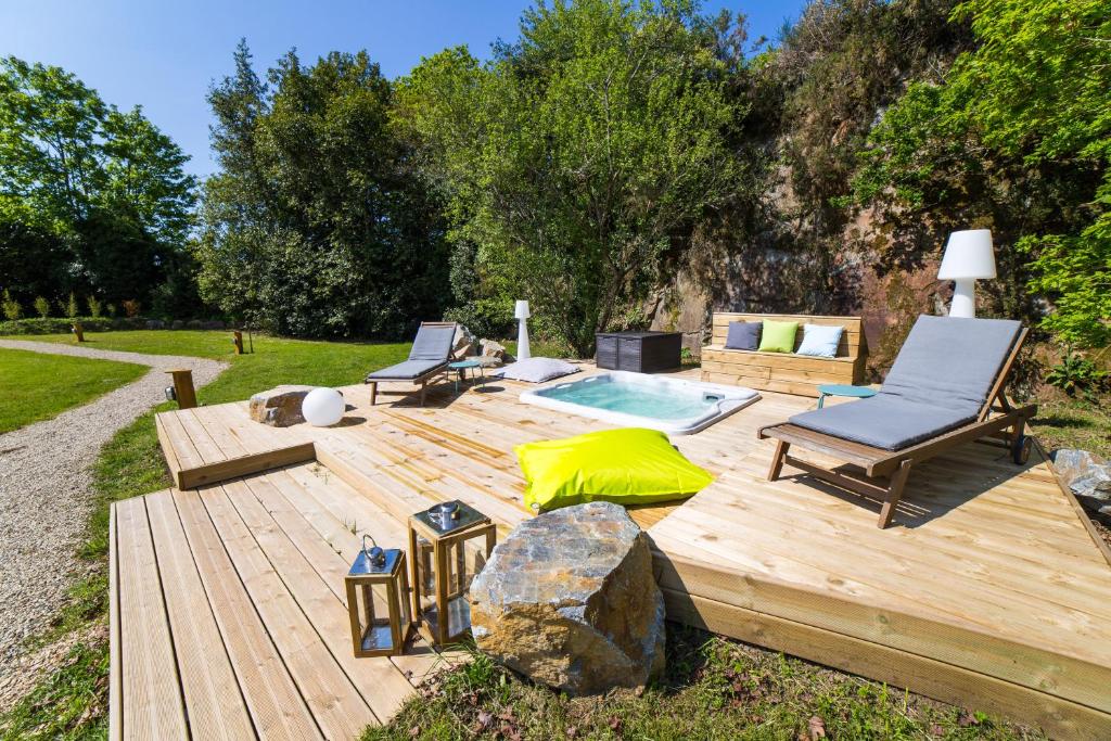 eine Holzterrasse mit 2 Stühlen und einem Pool in der Unterkunft La Carri'air in Pont-Aven