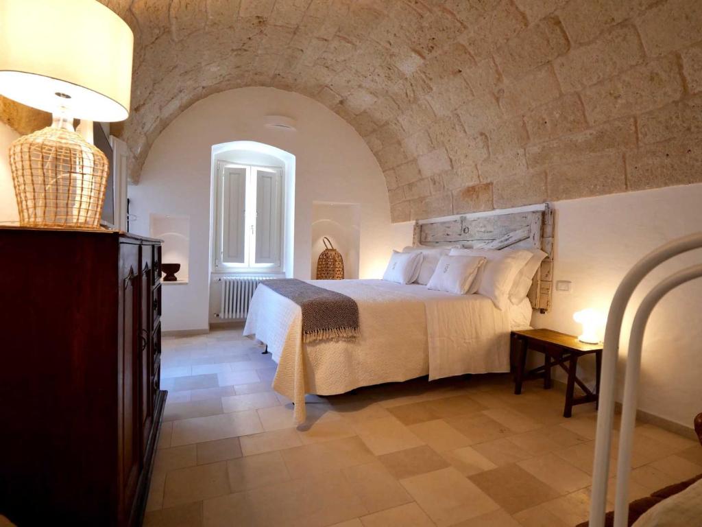 a bedroom with a large bed with a stone wall at Suite Sirene in Polignano a Mare