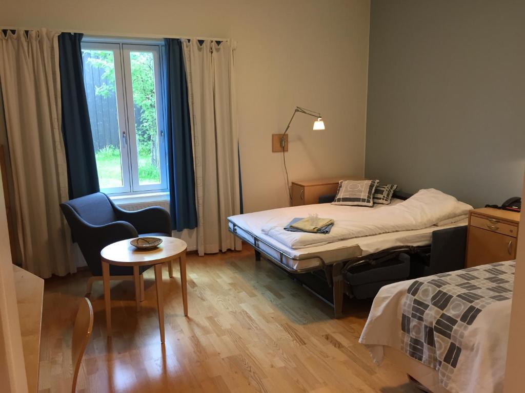 レーロースにあるUnicare Rørosのベッド2台、テーブル、窓が備わる客室です。