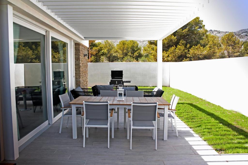 een patio met een houten tafel en stoelen bij Los Tilos in Alcossebre