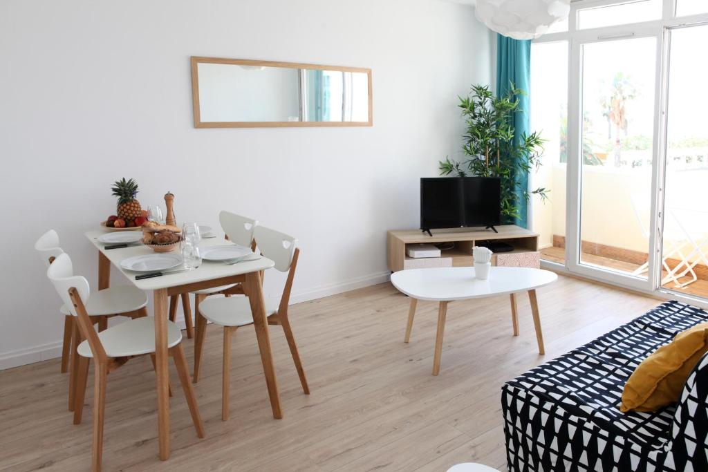 a living room with a table and chairs and a couch at Résidence La Corvette in Toulon