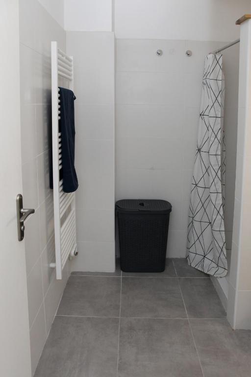 a bathroom with a door and a trashcan in a room at Résidence La Corvette in Toulon