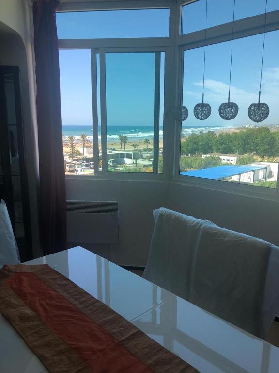 a dining room table with a view of the ocean at Nouveau appartement vue sur mèr , renouvelé en entier in Asilah