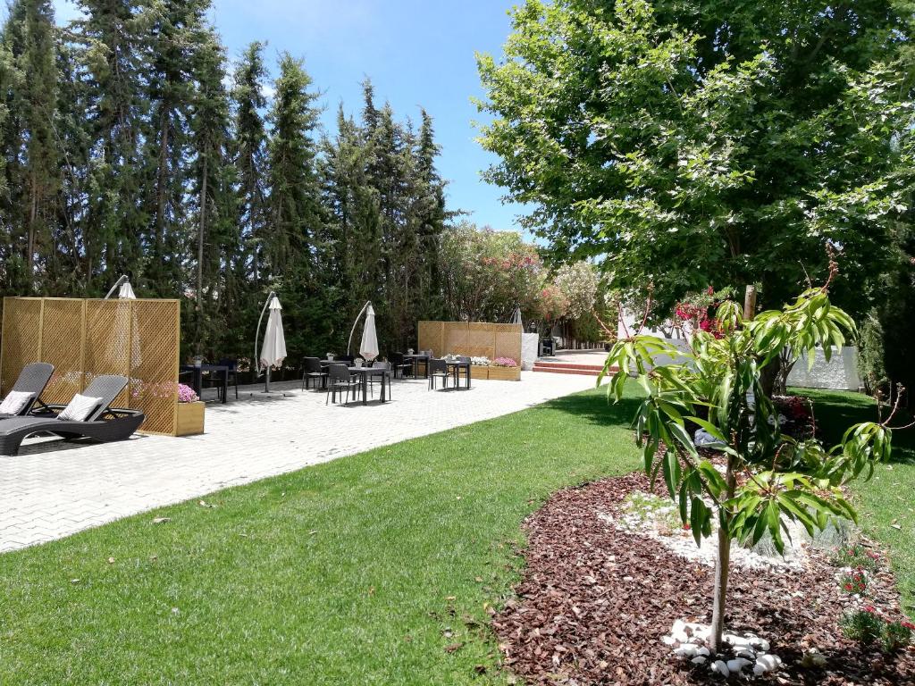 a garden with chairs and tables and a tree at Manta Guest - Bed & Breakfast in Manta Rota