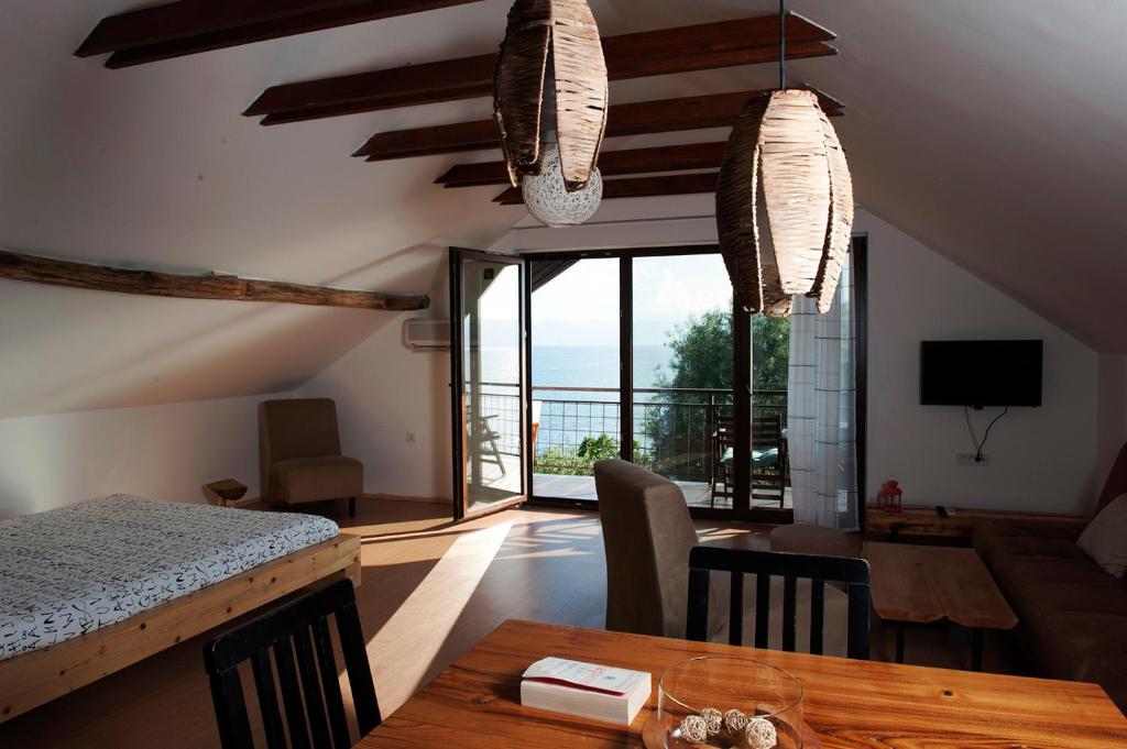 Sala de estar con mesa y vistas al océano en Villa Pavlina en Ohrid