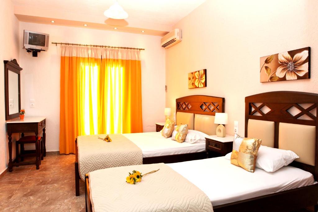 a hotel room with two beds and a television at Maria Studios in Neo Klima