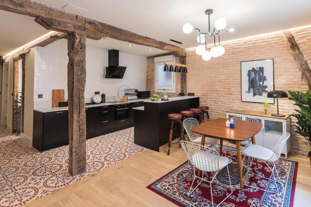 cocina y sala de estar con mesa y sillas en Miribilla by Staynnapartments, en Bilbao