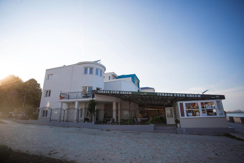 a white building with a sign on the side of it at Vila Gladiola in Eforie Nord