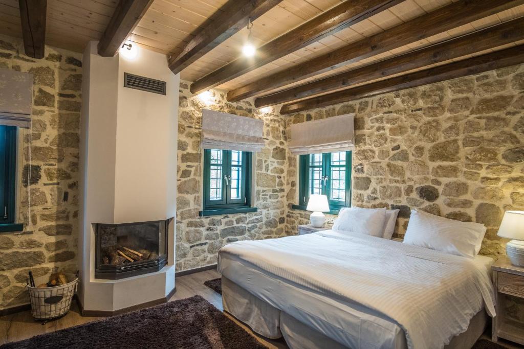 a bedroom with a bed and a fireplace at Hotel Arhontiko Vourloka in Pramanta