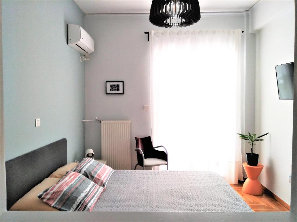 a bedroom with a bed and a large window at Athens Pangrati modern apt 10min to metro in Athens